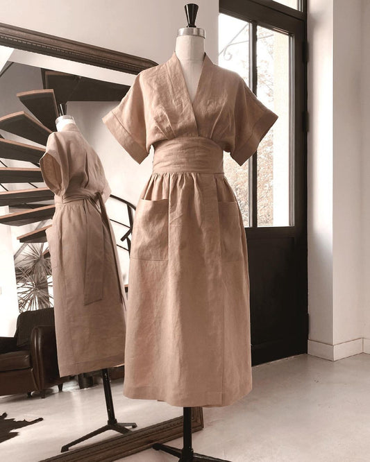 Helena Wrap dress in linen on a dressform in front of a large mirror