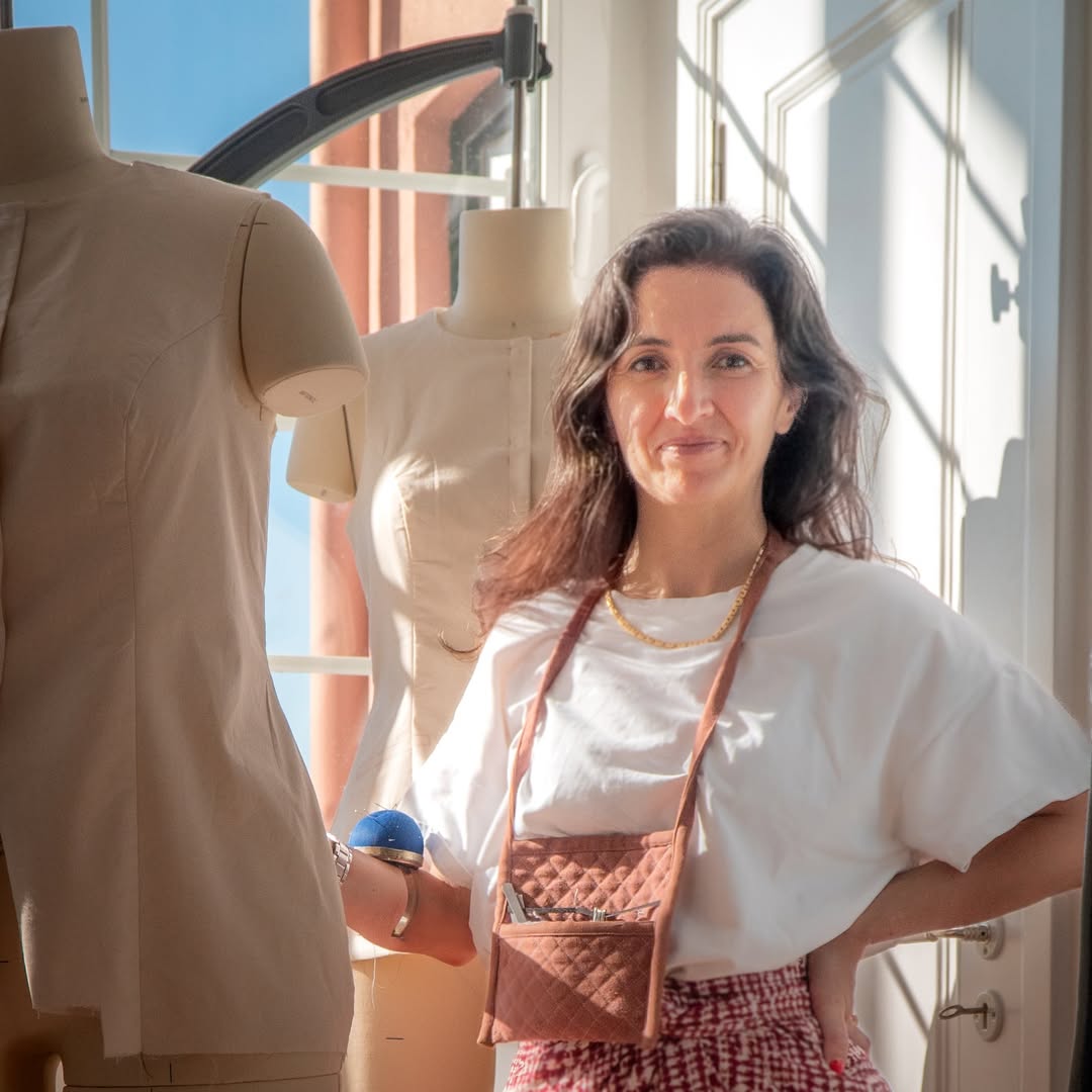 Delphine, creator and designer of Just Patterns stading next to dress forms