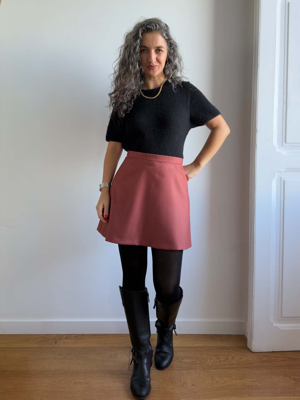 Karlie Skort sewing pattern, view A in the longer length in rust wool, hand on hip